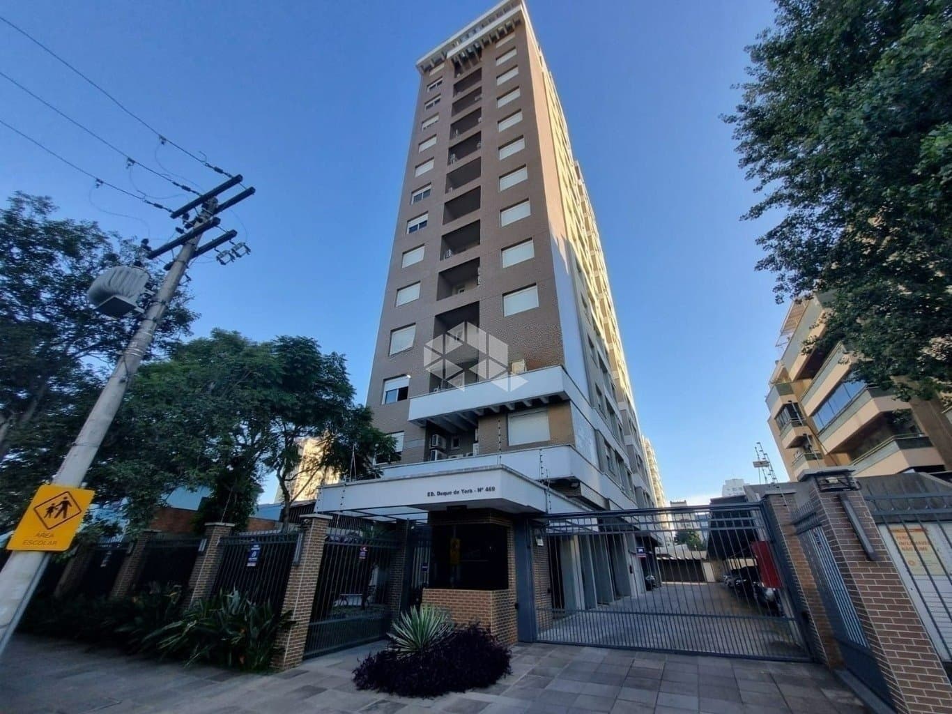 Fachada frontal do edificio com portaria e portao de acesso